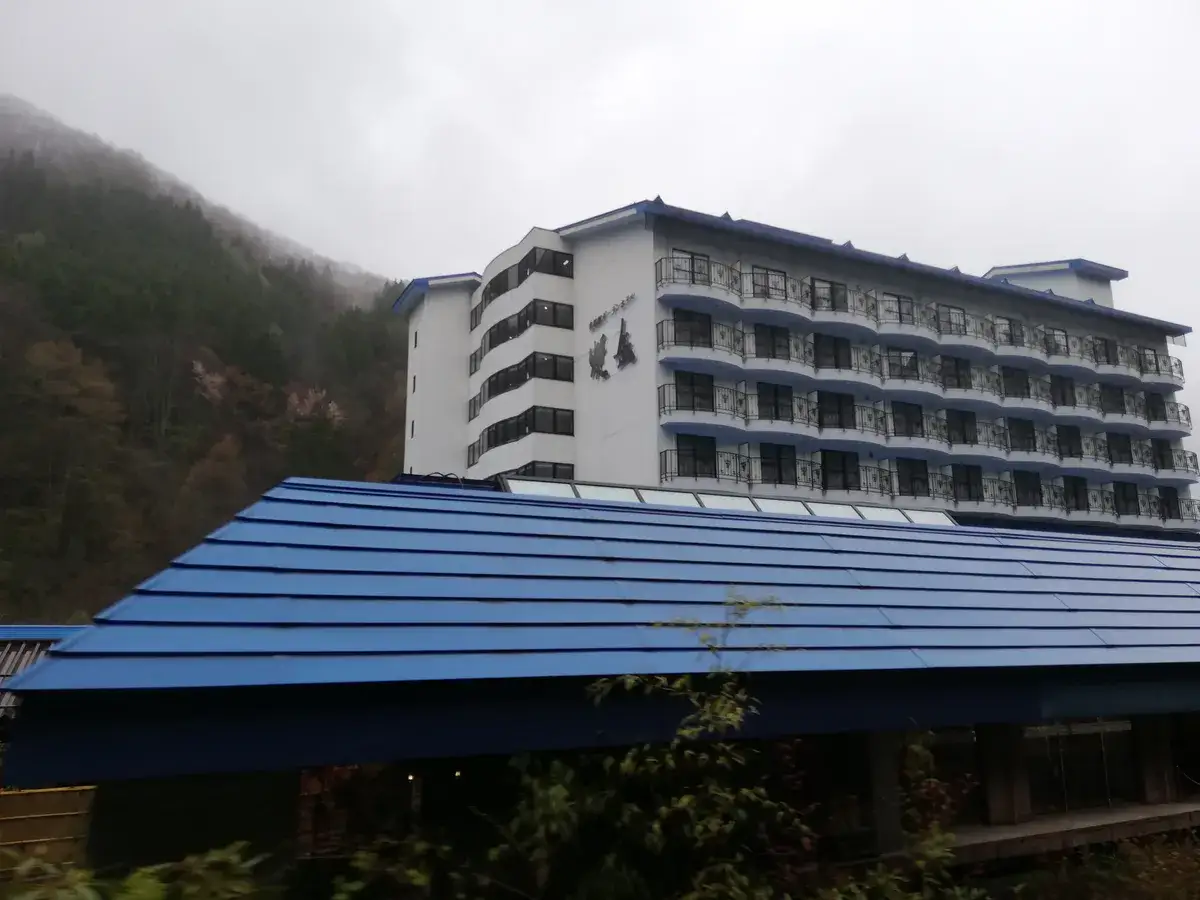 Okuhida Garden Hotel Yakedake exterior below wooded slopes